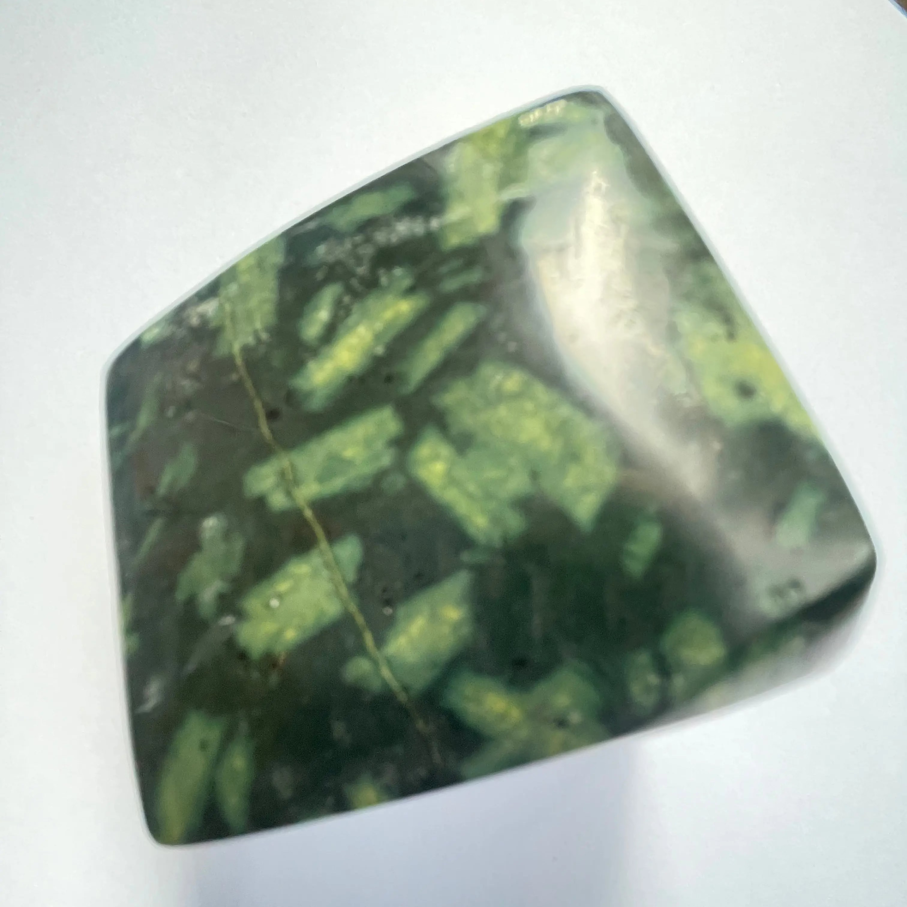 Green and black patterned stone on a white background