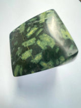 Green and black patterned stone on a white background