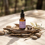 Amber Bottle with dropper 25ml Release Quantum Remedy with pink label on dried wood and leaves with pebbles around