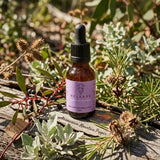 Amber dropper bottle 25ml Release Quantum Remedy with pink label on log with plants essence was made from Tasmanian Mountain Pepper with Silky Hakea Needle Bush and Old man salt bush and cockle shell
