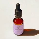 A small amber glass dropper bottle with a black cap and a lavender label reading 'Reprieve Quantum Remedy', photographed on a white background with a strong cast shadow.